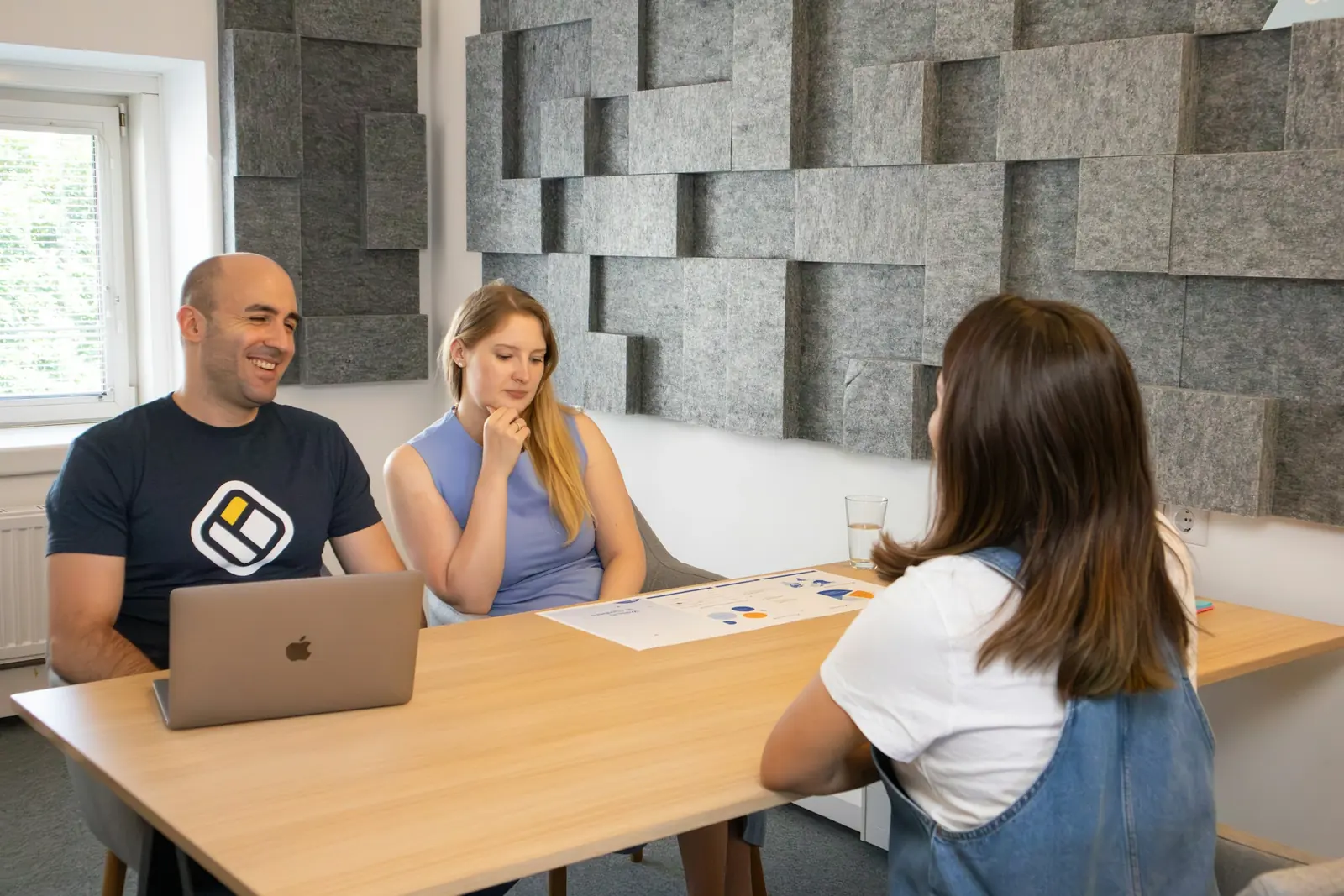 A team working together around a table with a laptop